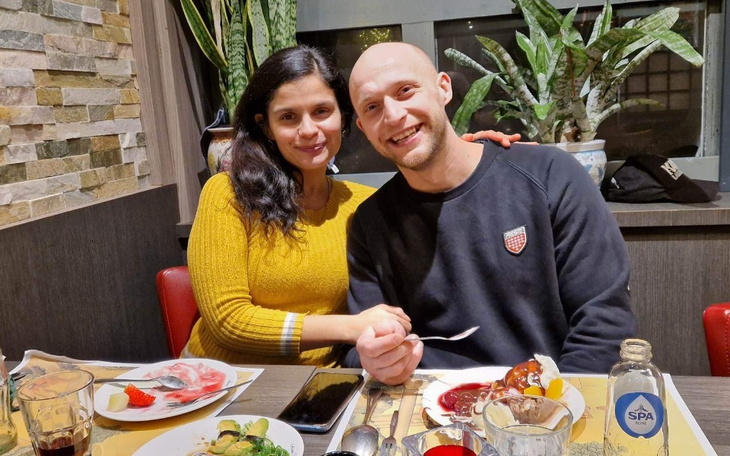 Para przy stole w restauracji, ciesząca się wspólnym posiłkiem.