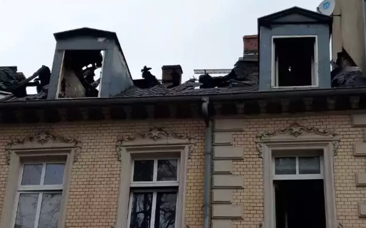 Zniszczony dach budynku po pożarze, widoczne uszkodzenia.