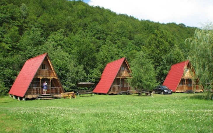 Trzy domki letniskowe w otoczeniu zieleni, idealne na wypoczynek.
