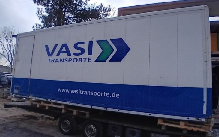 Naczepa ciężarówki z logo firmy transportowej.