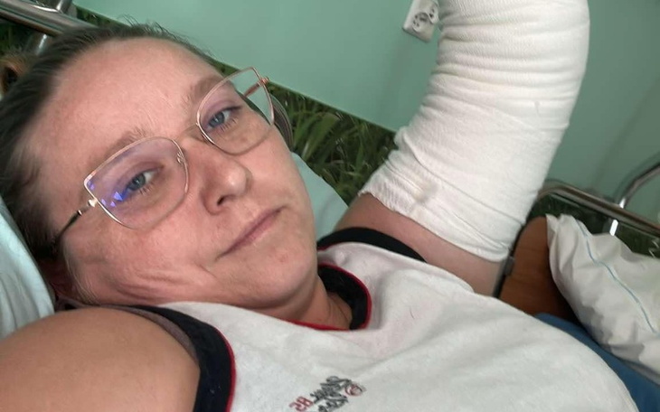 Kobieta z opatrunkiem na ręce, leżąca w szpitalnym łóżku.