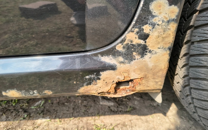 Zardzewiała część samochodu, wymagająca naprawy.