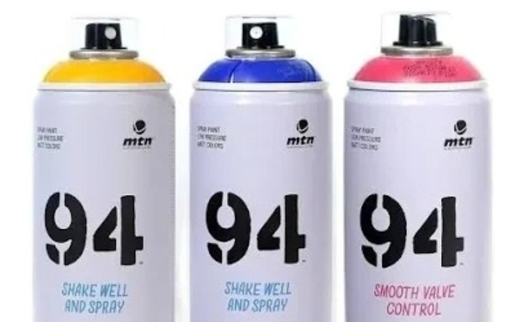 Trzy puszki sprayu w różnych kolorach.