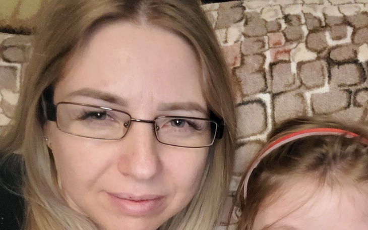 Zdjęcie kobiety z dzieckiem, uśmiechnięte i szczęśliwe.