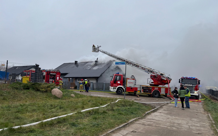Pożar domu, strażacy walczą z ogniem.
