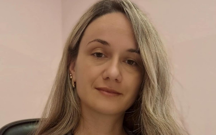 Kobieta z długimi włosami, siedząca w biurze.
