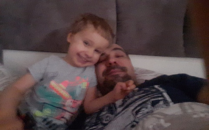 Mężczyzna leżący w łóżku szpitalnym, z poważnym wyrazem twarzy.