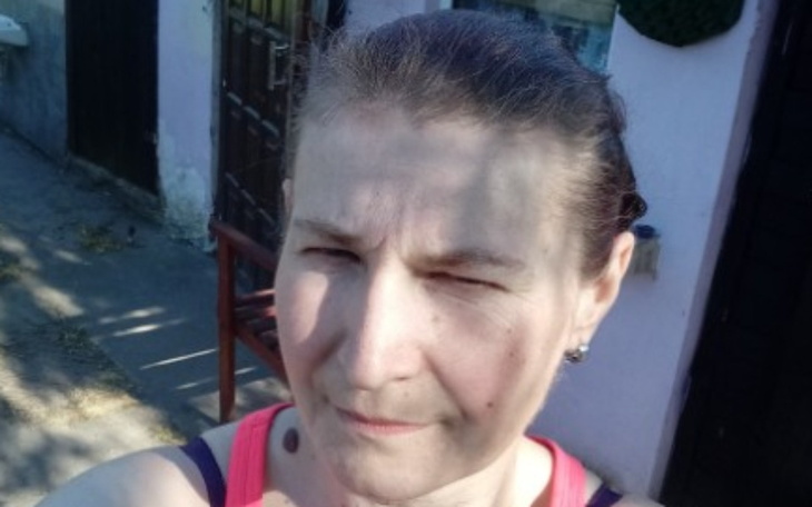 Kobieta robiąca selfie na tle domu.