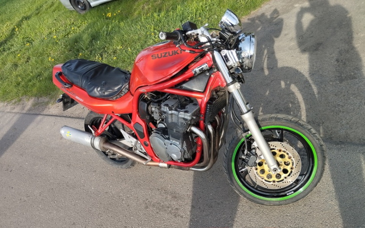 Motocykl Suzuki w czerwonym kolorze, zaparkowany na drodze.
