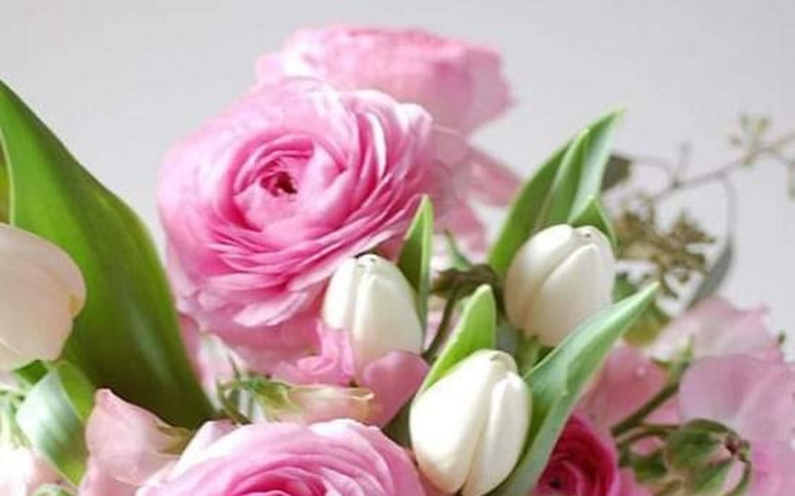 Bukiet różowych kwiatów, w tym tulipany i ranunkule.