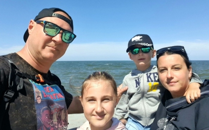 Rodzina na plaży, ciesząca się wspólnym czasem w słoneczny dzień.