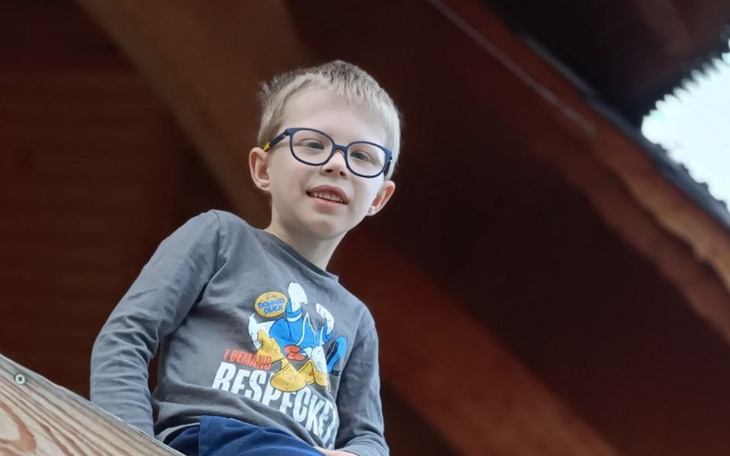 Chłopiec w okularach uśmiechający się z wysokości.