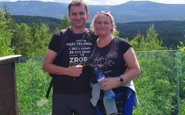 Para na tle górskiego krajobrazu, uśmiechnięta i szczęśliwa.