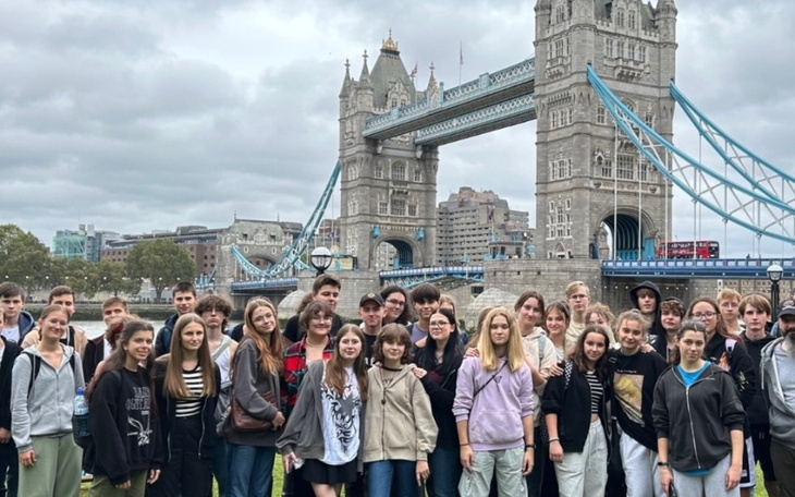 Grupa młodzieży pozująca przed Tower Bridge w Londynie.