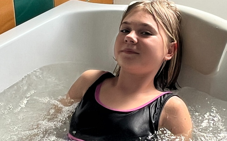 Dziewczynka relaksująca się w wannie z wodą.