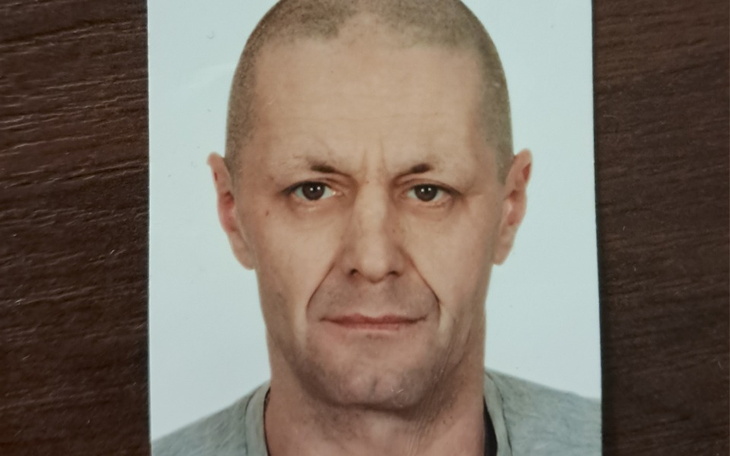 Zdjęcie mężczyzny z krótkimi włosami, patrzącego w obiektyw.