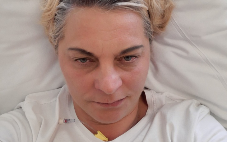 Kobieta leży w szpitalnym łóżku, wygląda na zmęczoną.