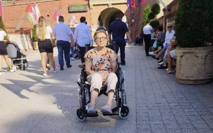 Kobieta na wózku inwalidzkim w miejskim otoczeniu.