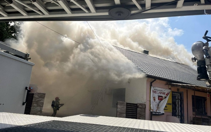 Pożar w budynku, strażak walczy z ogniem w chmurze dymu.