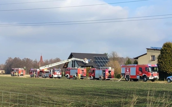 Akcja ratunkowa z wozami strażackimi przy budynku.