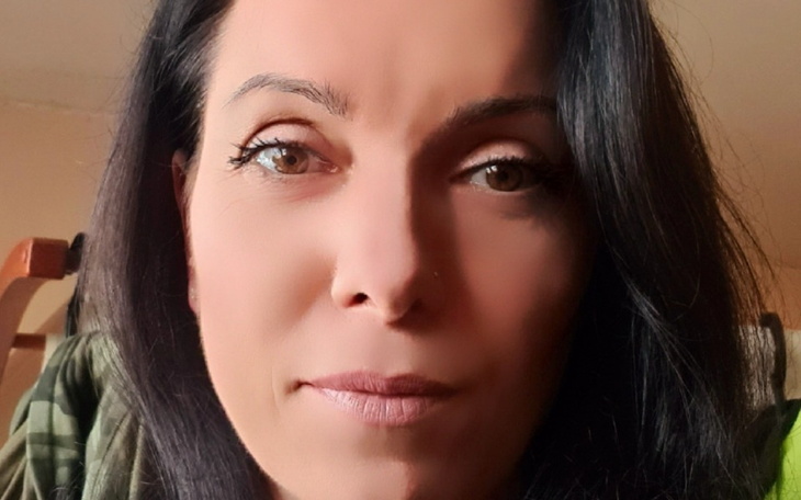 Portret kobiety z długimi włosami, patrzącej w kamerę.