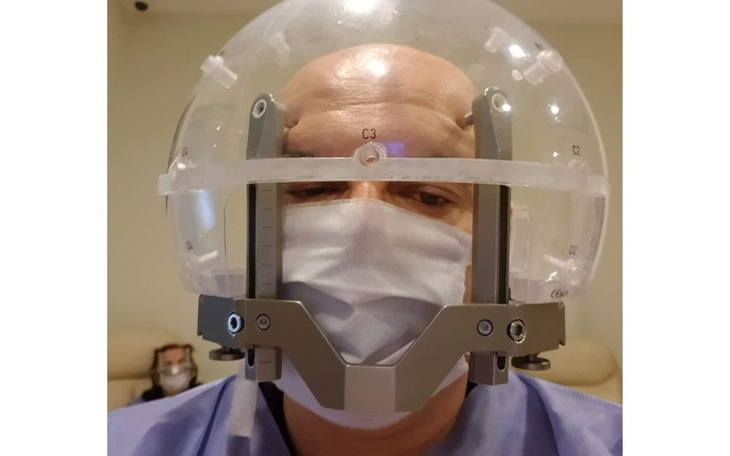 Mężczyzna w specjalnym hełmie medycznym, przygotowany do zabiegu.