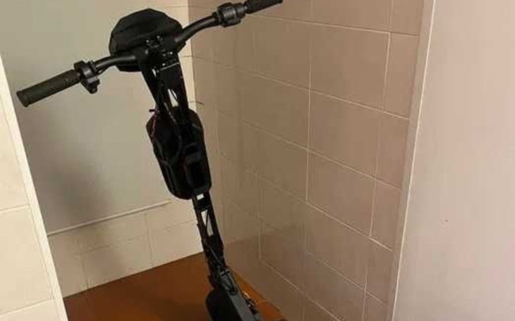 Skuter elektryczny zaparkowany w wąskim korytarzu.