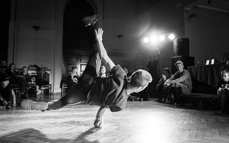Tancerz wykonujący ruchy breakdance na parkiecie.