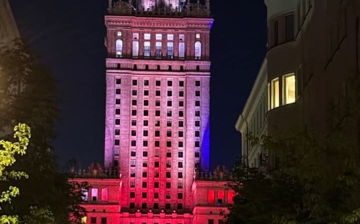 Wieżowiec oświetlony nocą, z kolorowymi światłami.