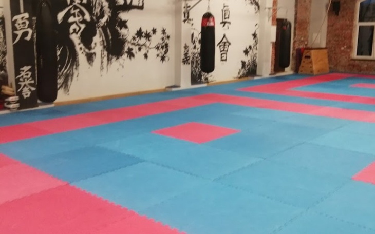 Pusty dojo z kolorowymi matami do sztuk walki.