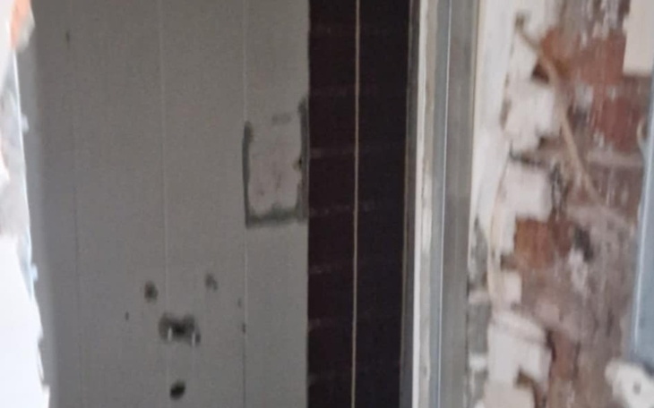 Zniszczone wnętrze budynku, widok na ścianę.