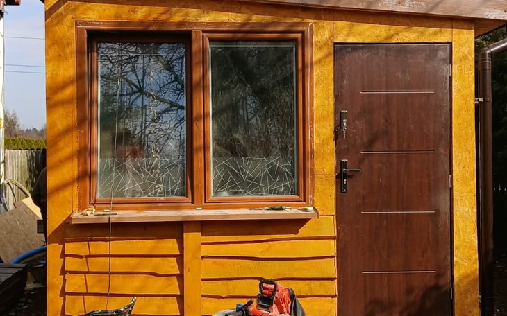 Mały domek z oknami, zbudowany z drewna.