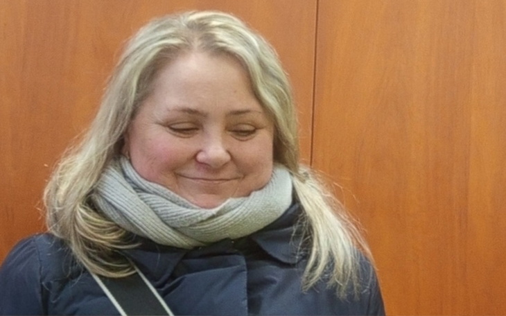 Kobieta z uśmiechem, ubrana w ciepły szalik.