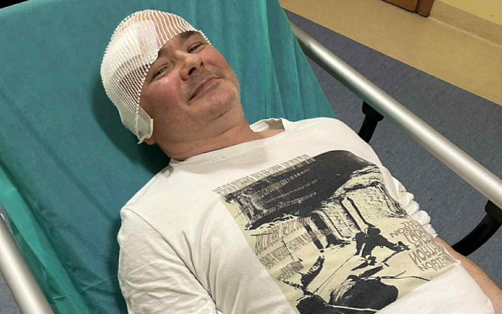 Mężczyzna w szpitalu z opatrunkiem na głowie.