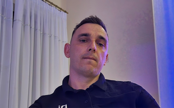 Mężczyzna w koszuli, selfie w jasnym pomieszczeniu.