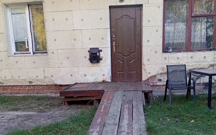 Wejście do budynku z drewnianym podjazdem.