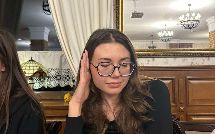 Młoda kobieta w okularach, zamyślona w restauracji.