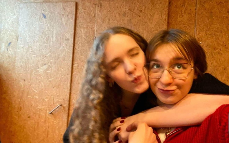 Dwie przyjaciółki pozujące razem, uśmiechnięte.