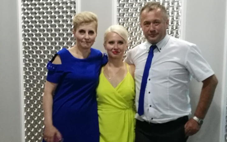 Trzy osoby pozujące do zdjęcia na imprezie.