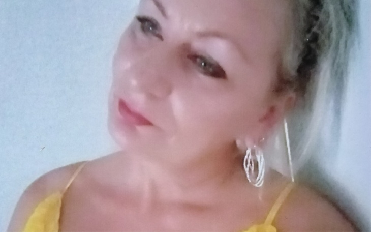 Kobieta w żółtej bluzce, patrząca w dal.