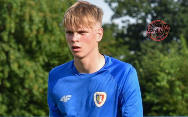 Młody sportowiec na boisku, skupiony na grze.