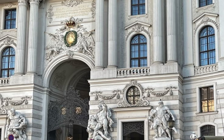 Imponująca fasada budynku z rzeźbami i zdobieniami architektonicznymi.