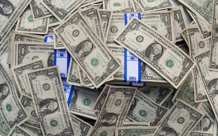 Stos banknotów dolarowych na stole.