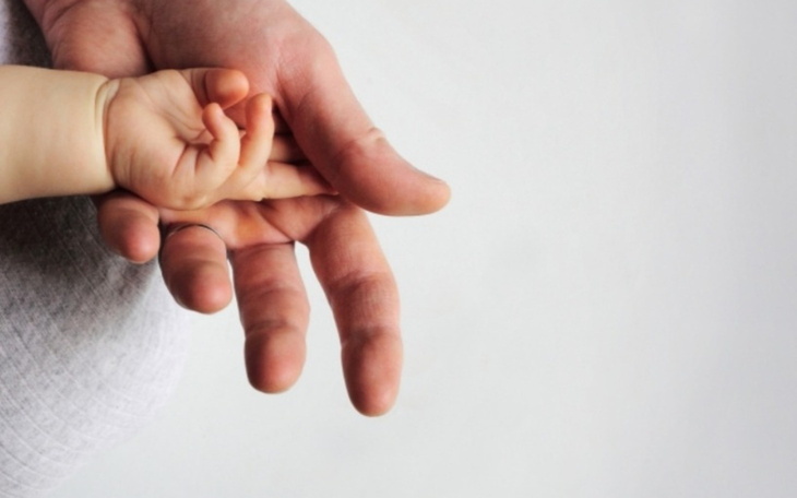 Dziecięca rączka trzymająca dłoń dorosłego, symbol miłości.