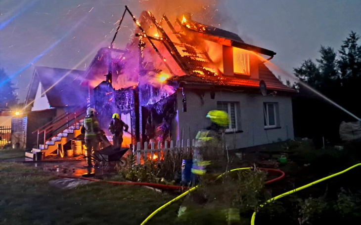 Pożar domu, strażacy walczą z ogniem w trudnych warunkach.