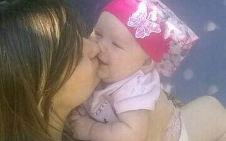 Mama całująca swoje dziecko, oboje uśmiechnięci.