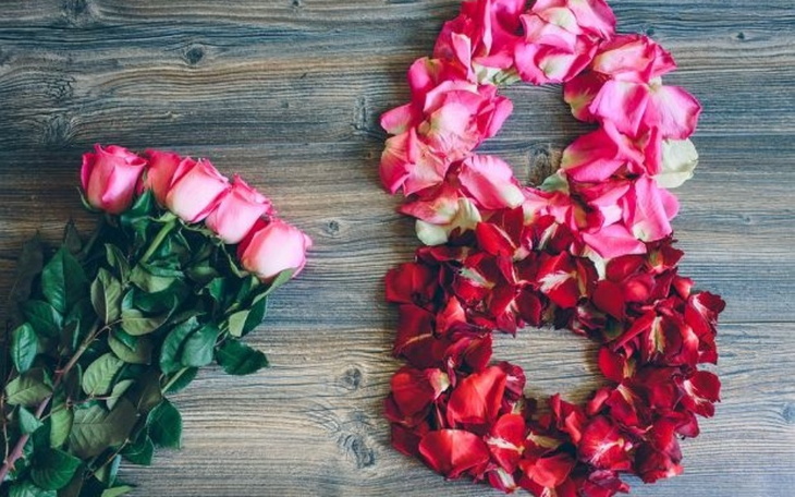 Róże ułożone w kształt serca na drewnianym tle.