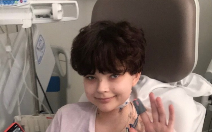 Młoda dziewczyna w szpitalu, uśmiechająca się do kamery.