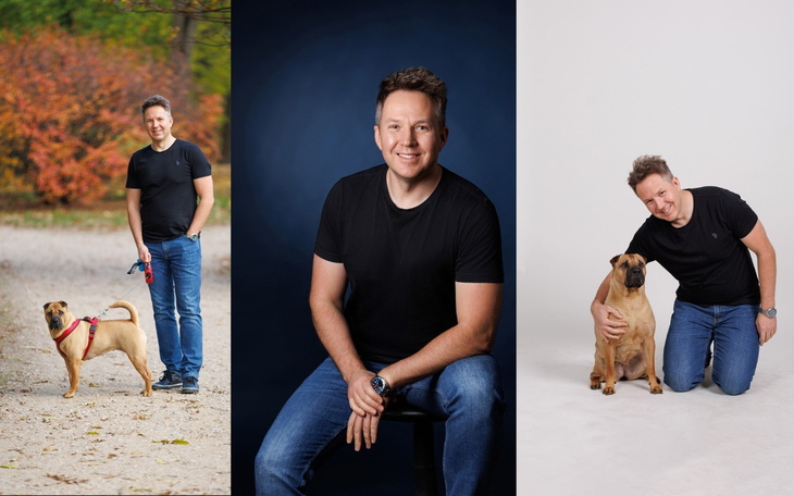 Mężczyzna pozujący z psem w parku w jesiennej scenerii.