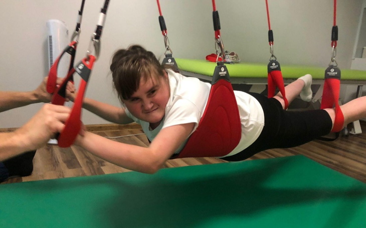 Dziewczynka w specjalnym sprzęcie, unosząca się w powietrzu.